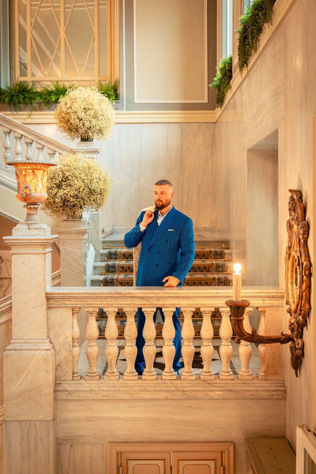 Felix Blume in a blue suit on a marble staircase